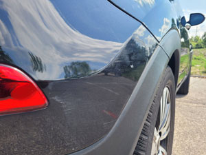 Detailaufnahme eines Schadens am Fahrzeugheck